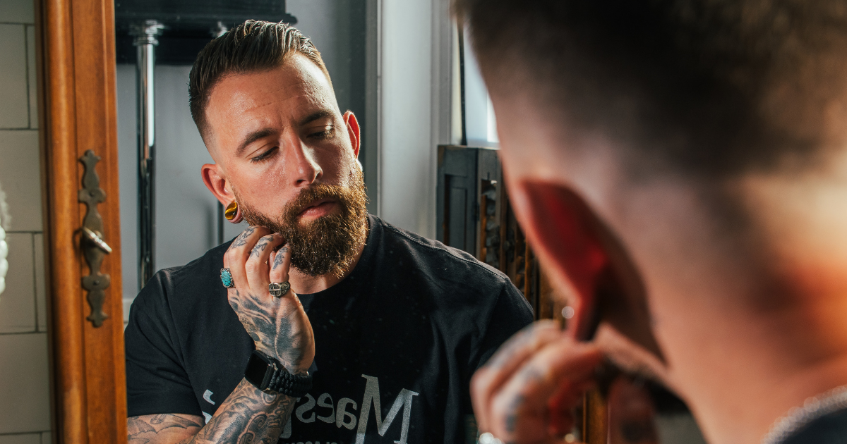 man working beard butter into his beard
