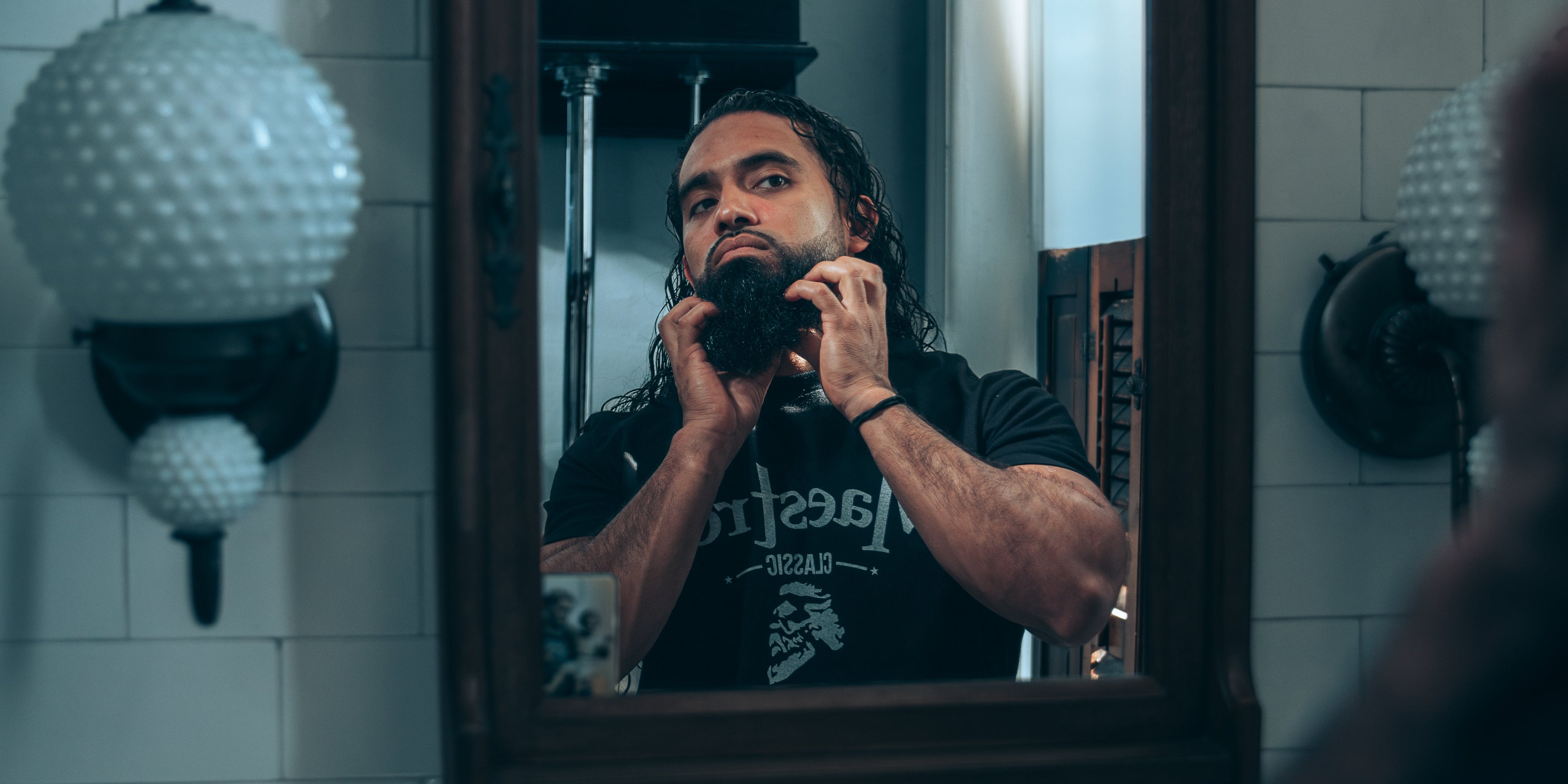 Man applying beard butter into damp beard after washing it.