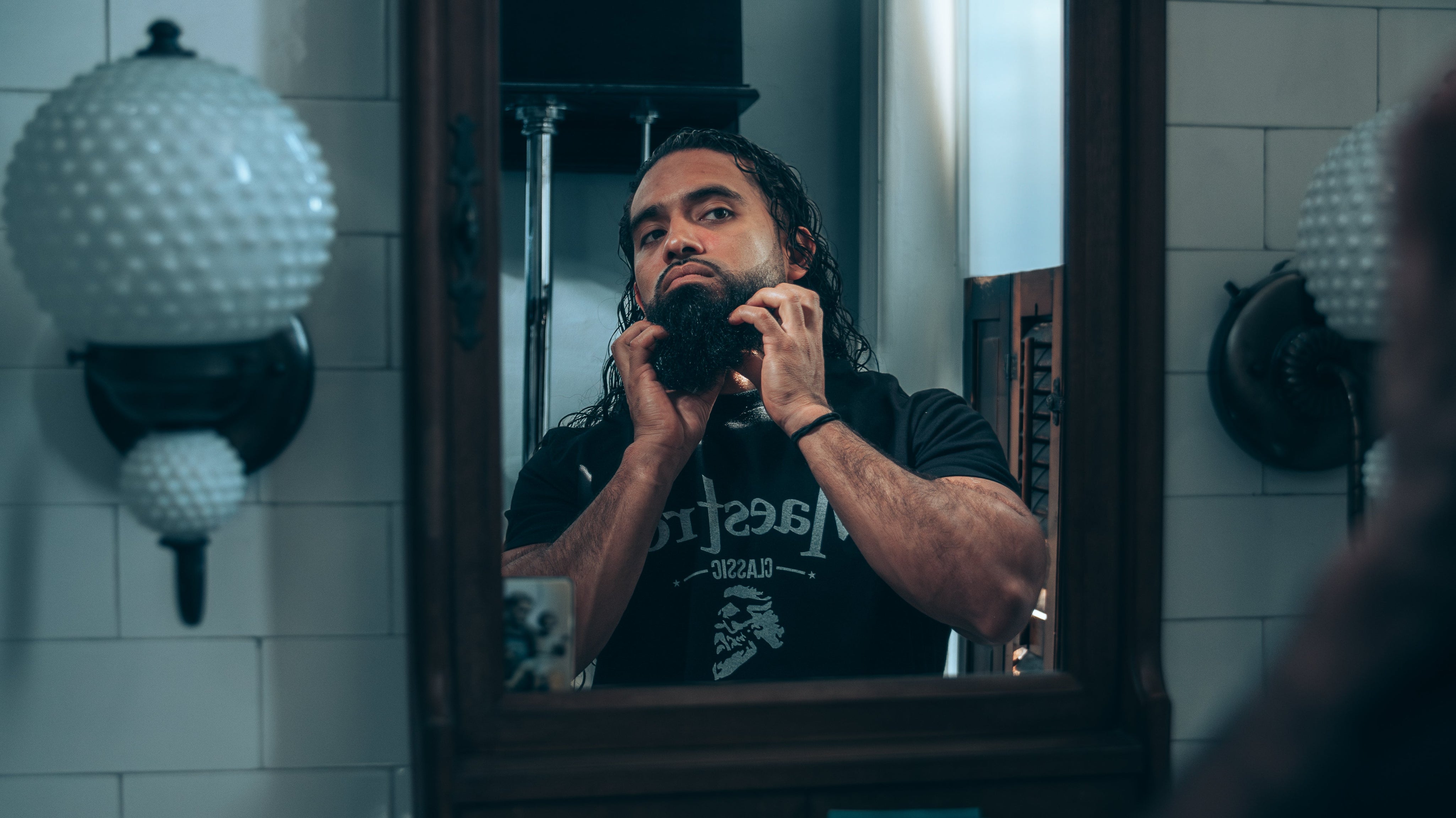Man applying beard butter into damp beard after washing it.