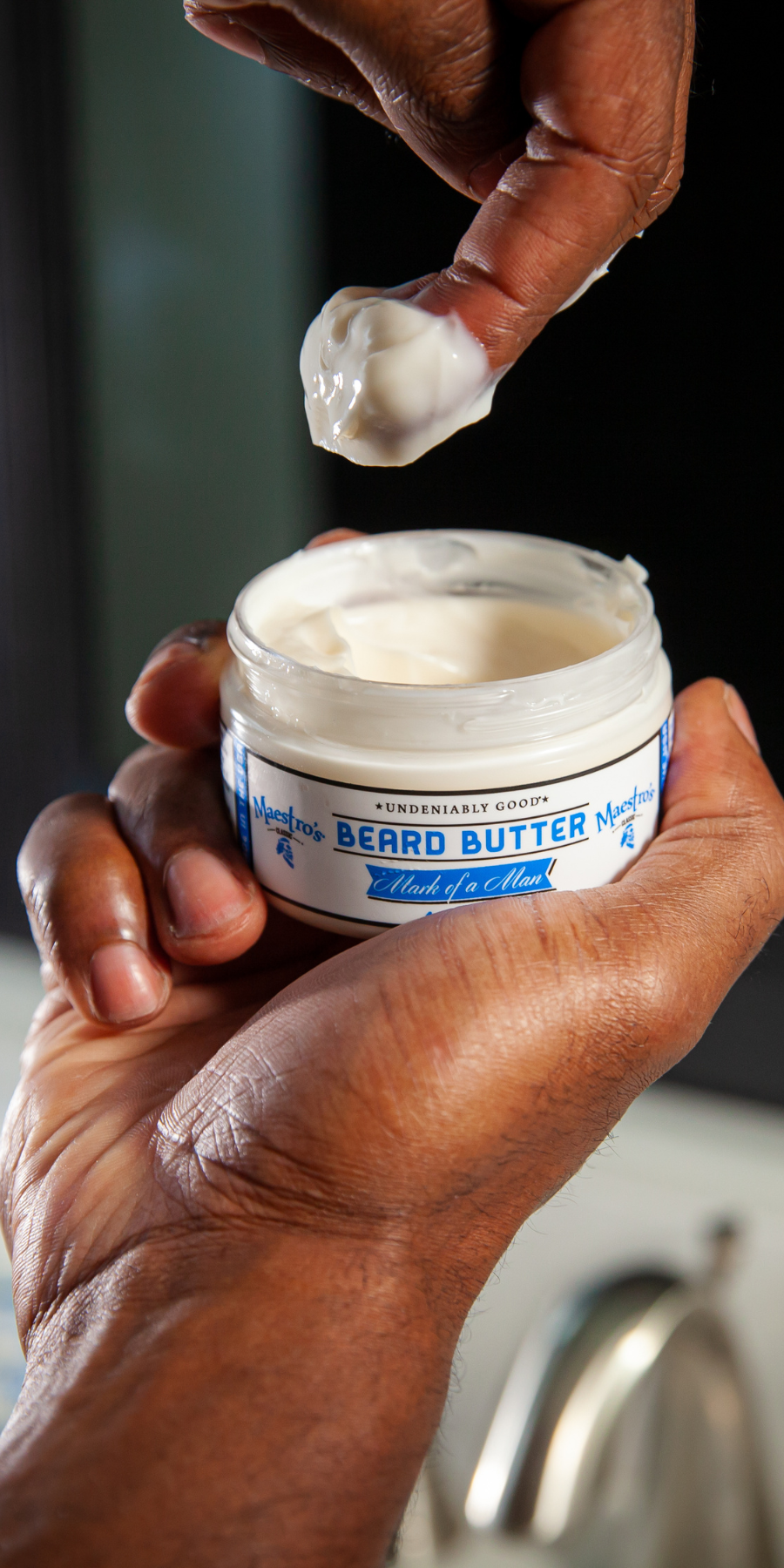 Hand scooping beard butter from a jarl